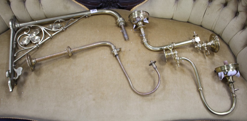 Three assorted brass gas wall light fittings and a larger drop wall light bracket